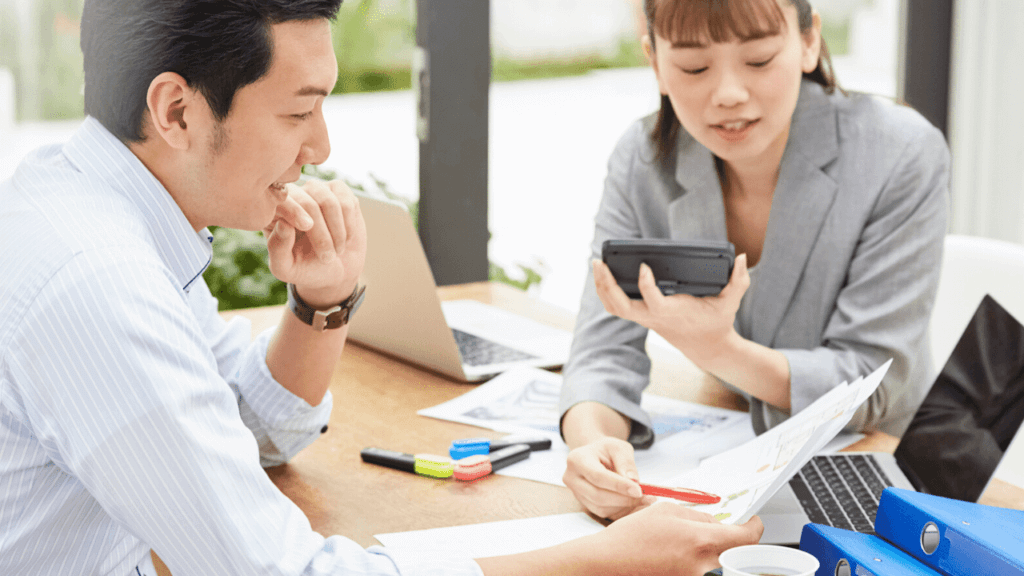 電卓を使って書類を検証する男女