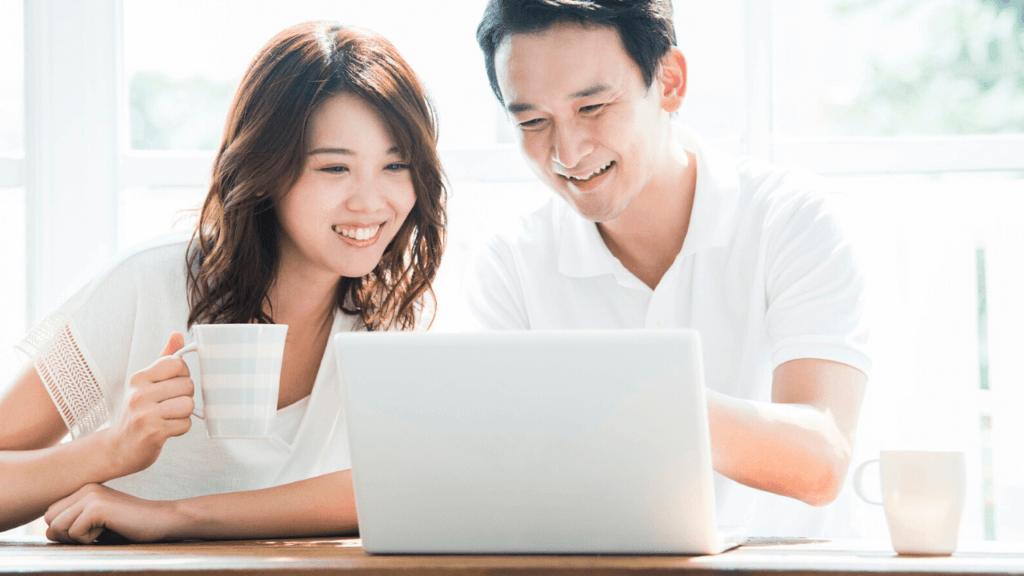 満足そうにパソコンで物件情報を見ている夫婦