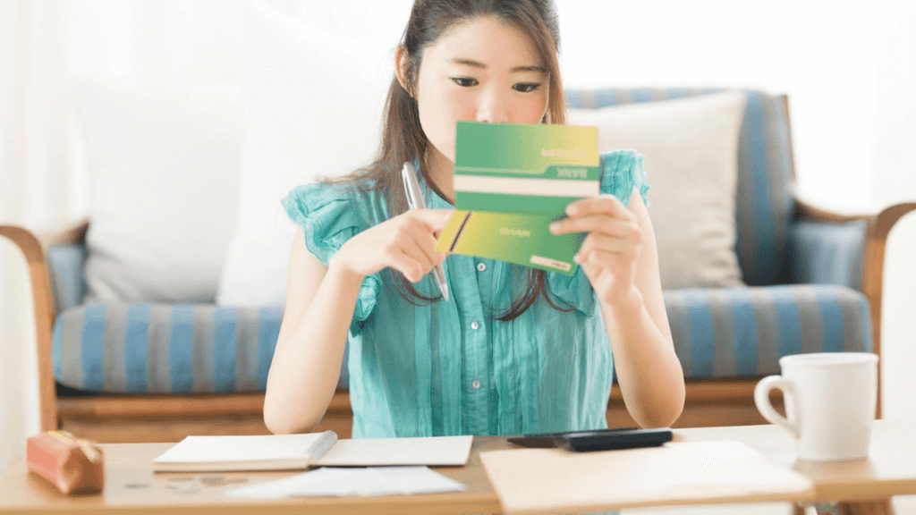 通帳を確認する若い女性